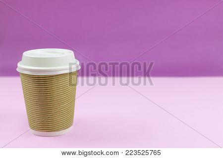 Take out paper coffee cup on purple and pink background. Copy space. Mock up.