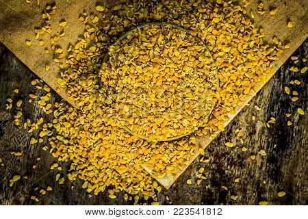 Crushed Fenugreek Seeds,trigonella Foenum-graecum Seeds,methi Ke Koriya In A Bowl On Wooden Surface.