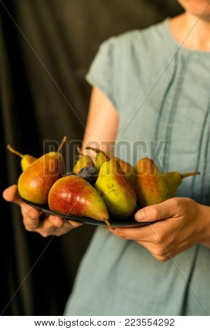 Close up female hands holding plate with summer fruit healthy diet concept