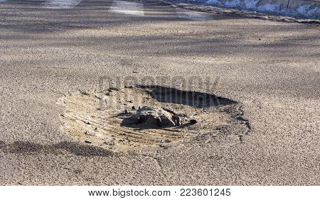 there are many potholes on the roadway close-up