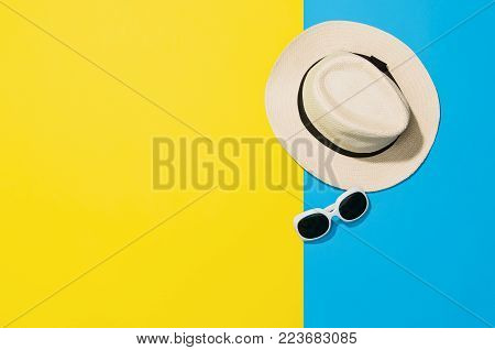 Top view of sandy beach with towel frame and summer accessories. Punchy pastels colors graphical background with copy space. Right border made of towel