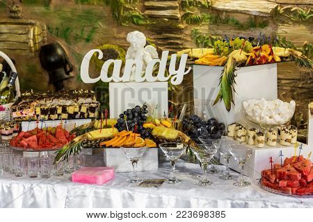 Dessert table for a party. Ombre cake, cupcakes. Wedding