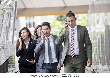 Businesspeople Using Smartphone For Talk Business Project While Walking. Businesspeople  Working Con