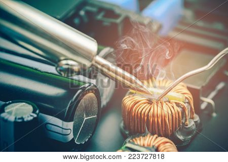 technician repair electronic circuit board with soldering iron