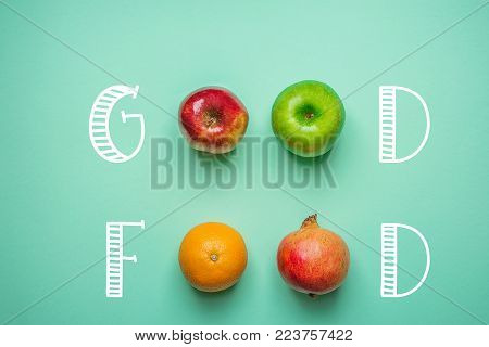 Hand Lettering Good Food on Turquoise Background with Fruits Orange Green Red Apples Pomegranate. Healthy Clean Eating Vegan Vitamins Energy Concept. Creative Mixed Media Poster.