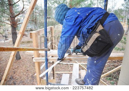 KYIV, UKRAINE - February, 05, 2018: Contractor Cutting Soffits Board. Roofing Repair. Fascia and Soffit Repair.