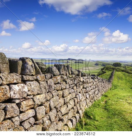 Dry stone wall running the same course as Hadrian's Wall in Northumberland, and probably making use of stones recycled from the wall.