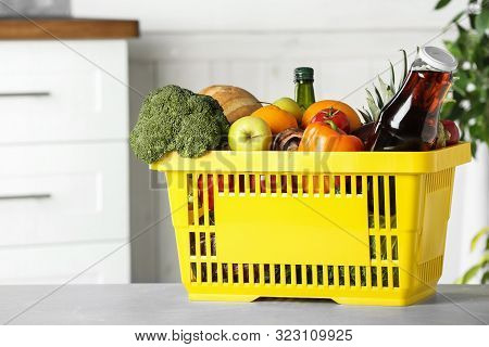 Shopping Basket With Grocery Products On Grey Table Indoors. Space For Text