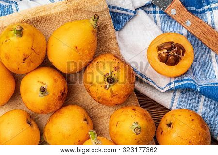 Fresh Loquats (medlars) On Wooden Background. Rustic And Healthy Appearance. Close-up.top View.