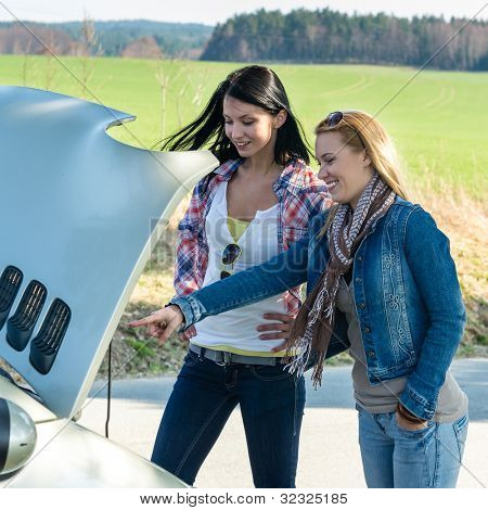 Le donne di ripartizione auto guardando sotto cofano punto motore motore
