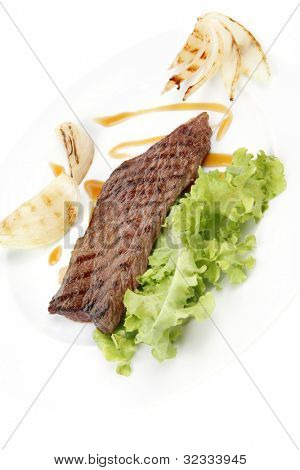 肉料理： 焼きステーキ緑レタスのサラダ ロースト玉ねぎ、白の bac に分離された皿の上に