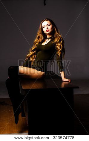 Beautiful Dancer. Girl Model. The Girl Sits In A Hat And Sits On A Table. Girl In A Beautiful Underw