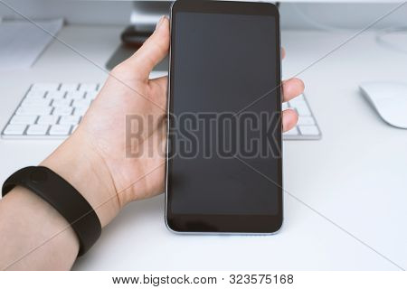 Woman Hand Holding Smartphone With Broken Display. Crashed Device At Wokrplace