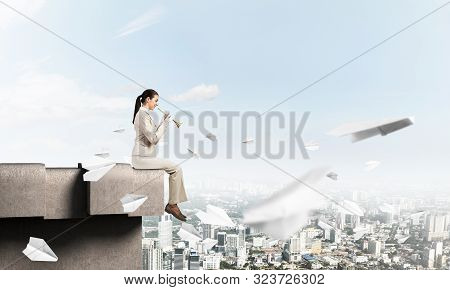 Attractive Young Woman Playing Music On Roof Of Building. Brave Businesswoman With Trumpet Instrumen