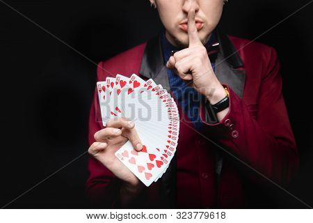 Disclosure Of Focus. Magician Shows Trick With Playing Same Cards On Dark Background