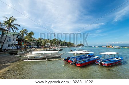 Sabang, Puerto Galera, Philippines - January 13, 2017: Seascape Of Pier Sea, Blue Sky, Palms And Boa