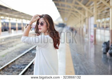 Back View Portrait Of Young Asian Woman In White Dress With Sun Glassess Standing And Pose In Train 