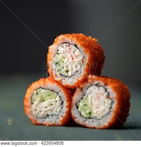 Inside-out Sushi Set. Pyramid Of Three Sushi. Rolls In Masago Or Tobiko Caviar On Gray Blurred Backg