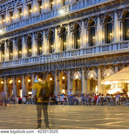 Saint Mark Square in Venice at nigh with ghost of lonely postpandemic tourist, Italy