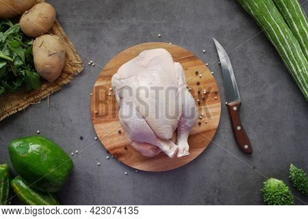 Raw Whole Chicken On A Chopping Board With Fresh Vegetable