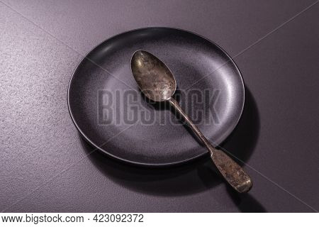 Dark Ceramic Plate And Vintage Spoon As A Table Settings Style