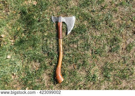 The Battle Ax Is On The Ground Next To A Large Stone. Forged Ax