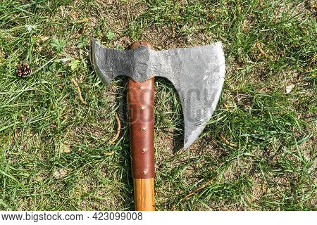 The Battle Ax Is On The Ground Next To A Large Stone. Forged Ax