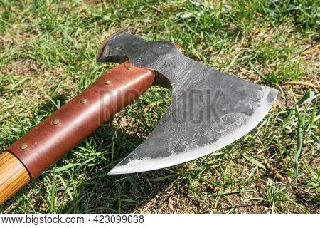The Battle Ax Is On The Ground Next To A Large Stone. Forged Ax