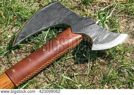 The Battle Ax Is On The Ground Next To A Large Stone. Forged Ax