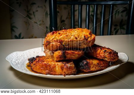 Marinated Char-grilled Pork Chops Ready To Serve At Kitchen Table