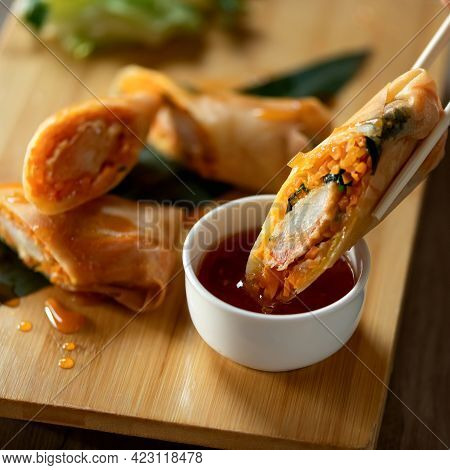 Springrolls, Pan-asian Rolls With Sweet And Sour Sauce. Oriental Dish And Bamboo Chopsticks On Woode