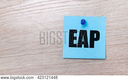 On A Light Wooden Background - A Light Blue Square Sticker With The Text Eap Employee Assistance Pro