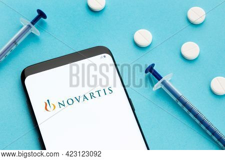 Galicia, Spain; June 8, 2020 : Smart Phone Showing Novartis Logo On Screen And Pills And Syringe On 