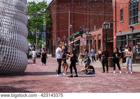 TORONTO, CANADA - 06 05 2021: Torontonians enjoying sunny weather and lifting of stay at home order in the historic district of the largest Candian city - Toronto