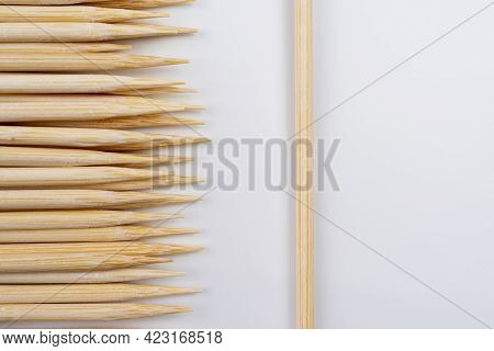 Many Wooden Bamboo Skewers Against Solid White Background , Concept Of Many Or One Skewers On A Whit