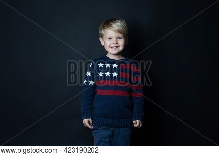 Smiling Kid In Sweater With Usa American Flag On Black Background With Copy Space.