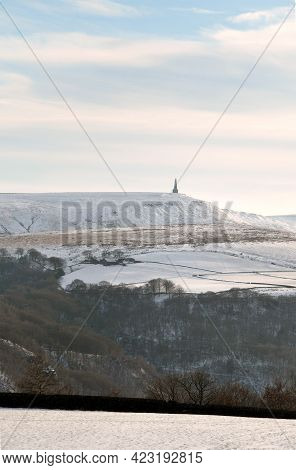 Snow Covered Fields With Stoodley Pike Monument And Moors In The Distance In Calderdale West Yorkshi