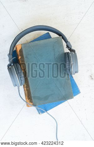 Audio Book Concept. Headphones With Books On Wooden Table. Top View With Copy Space.
