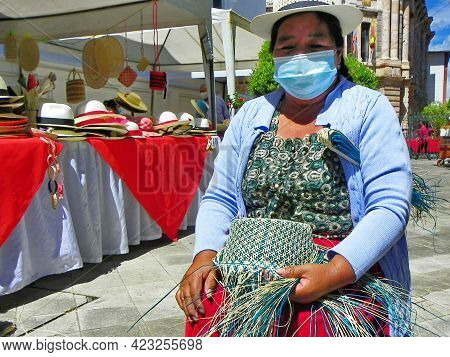 Cuenca, Ecuador - June 9, 2021: Indigenous Woman Demonstrates Tradition Weaving Of Panama Hat Or Paj