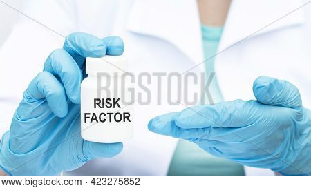 Risk Factor Inscription On A Can Of Medicine In The Hands Of A Doctor In Blue Styres, Close-up