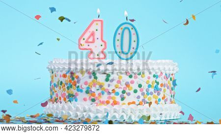 Colorful tasty birthday cake with candles shaped like the number 40.