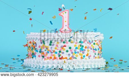 Colorful tasty birthday cake with candles shaped like the number 1.