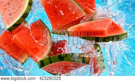 Fresh pieces of water melon falling in water with splash