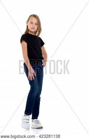 Pretty Blonde In A Black T-shirt. Girl In Fashionable Clothes Posing In The Studio. Full-length Port