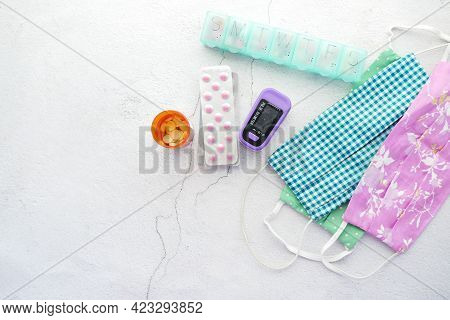 Pule Oximeter And Cloth Face Mask On Table