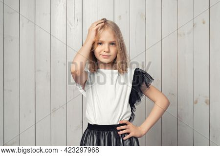 Oh, No. Photo Of Upset Blonde Teen Girl Made Big Mistake Feel Guilty. Studio Shot, Light Wooden Back