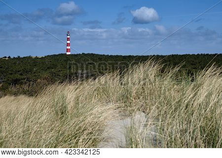 Classic, Historic Old Red And White Lighthouse With Dunes And Grass, Sunny Windy Day And Turbulent C