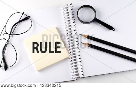 Word Rules On Sicker On Notebook With Pencils,magnifier And Glasses