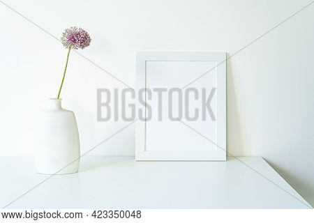 Empty White Picture Frame Mockup. Modern And Elegant Vase With Allium Ampeloprasum Flower Over White