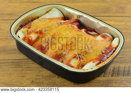 Foil Pan Full Of Baked Enchiladas Covered In Red Enchilada Sauce